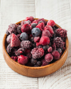 pot en bois avec des fruits rouges congelés